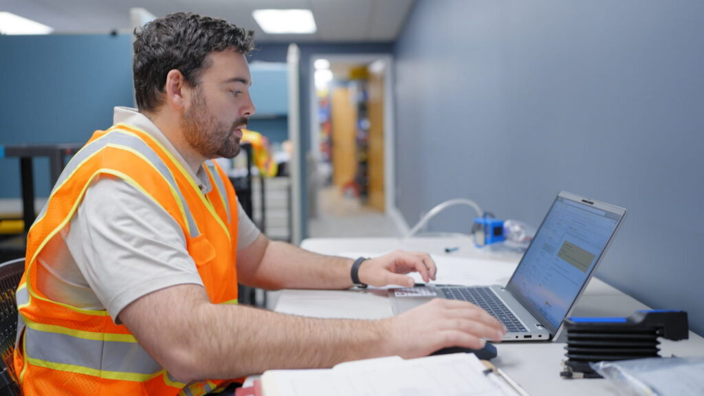 An auditor consulting a computer's noise level readouts.