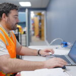 An auditor consulting a computer's noise level readouts.