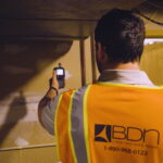A BDN employee testing for hazardous and toxic building materials.